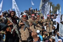FILE - Afghan Taliban militants and villagers attend a gathering as they celebrate the peace deal in the Afghan conflict with the U.S. in Afghanistan, in Alingar district of Laghman province, March 2, 2020.