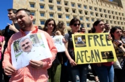 FILE - Journalists attend a rally to support Azerbaijani journalist Afgan Mukhtarli, in Tbilisi, Georgia, May 31, 2017.