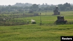 Indian security posts, right, are seen along the border between India and Pakistan in Suchetgarh near Jammu, Oct. 9, 2014. 