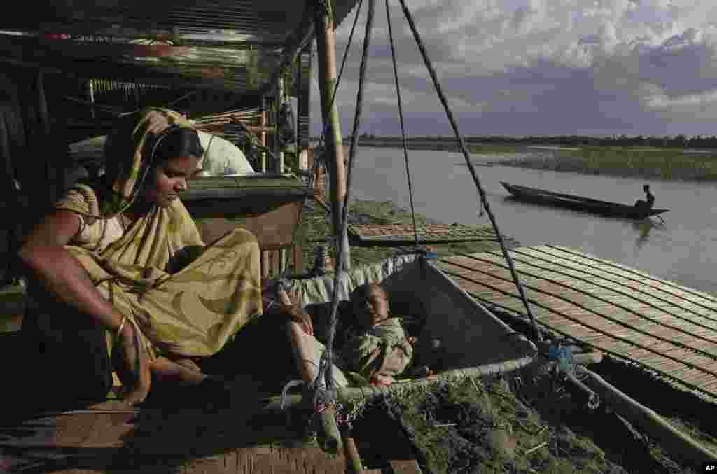 An Indian woman, Manira Biwi, sits near her one-month-old baby at a makeshift temporary hut in the flood affected Gagalmari village in Assam state, India, July 2, 2012. 