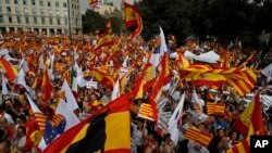 People wave flags of Catalonia and Spain as they celebrate a holiday known as "Dia de la Hispanidad" or Spain's National Day in Barcelona, Spain, Oct. 12, 2017.