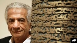 Iranian artist Parviz Tanavoli stands near a detail of his sculpture "Poet Turning into Heech," at the Davis Museum on the campus of Wellesley College in Wellesley, Mass. 