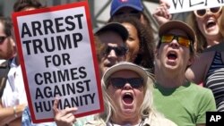 ក្រុម​សកម្មជន​កាន់​រូប​សញ្ញា​ប្រឆាំង​នឹង​គោល​ការណ៍​របស់​រដ្ឋ​បាល​លោក ត្រាំ ចំពោះ​ការ​ចាត់​ទុក​ការ​ឆ្លង​ព្រំដែនជា​បទ​ល្មើស​​ និង​ការ​បំបែក​កូន​ពី​ឪពុក​ម្តាយ​ កាល​ពី​ថ្ងៃ​សៅរ៍ ទី​៣០ មិថុនា ២០១៨។