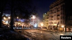 Riot police stand in a cordon facing a barricade of anti-government protesters in Kyiv, Feb. 3, 2014. 