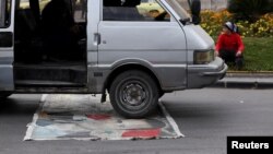 12일 시리아 다마스쿠스의 도로에서 한 차량이 바샤르 알아사드 시리아 전 대통령의 사진을 밟고 지나가고 있다.