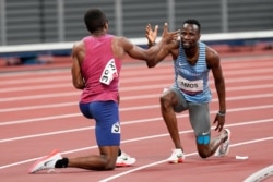Isaiah Jewett, of the United States, and Nijel Amos, right, of Botswana, shake hands after falling in the men's 800-meter semifinal at the 2020 Summer Olympics, Aug. 1, 2021, in Tokyo.