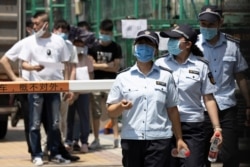 Workers leave from a coronavirus testing center set up outside a sports facility in Beijing, June 16, 2020.