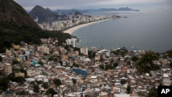 FILE - Brazil Favela Tourism, men overlook the city from the Vidigal slum, in Rio de Janeiro, Brazil, Oct. 29, 2017.