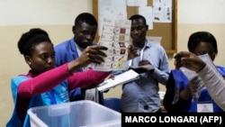 Uma delegada eleitoral mostra um boletim de voto durante a contagem no fim das eleições gerais em Luanda, Angola, 13 de Agosto 2017 (arquivo)