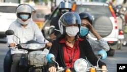 ប្រជាជន​កម្ពុជា​ពាក់ម៉ាស​ការពារ​វីរុសកូរ៉ូណា​ក្នុង​ទីក្រុង​ភ្នំពេញកាលពី​ថ្ងៃទី​២៨ ខែមករា ឆ្នាំ២០២០។(AP Photo/Heng Sinith)