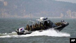 FILE - South Korean navy sailors in a speed boat patrol around South Korea's western Yeonpyong Island after finishing their exercise, near the disputed sea border with North Korea, February 20, 2012.