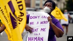 FILE - Clarissa Johnson of Hartford marches with members of the New England Health Care Employees Union, during a rally to demand new laws to protect caregivers and consumers, July 23, 2020, in Hartford, Conn. 