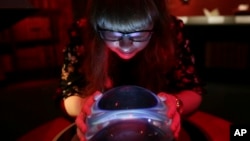 A member of British Library staff poses with a crystal ball for a picture at the "Harry Potter - A History of Magic" exhibition at the British Library, in London, Wednesday Oct. 18, 2017. The exhibition running from Oct. 20, marks the 20th anniversary of