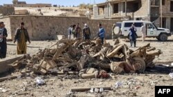 Security personnel and residents gather around the site of a car bomb attack that targeted an Afghan police headquarters in Feroz Koh, the capital of Ghor Province, Oct. 18, 2020. (AFP)