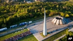 FILE - People line up to lay flowers at the monument to the victims of mass killings by Ottoman Turks, to commemorate the 106th anniversary of the massacre, in Yerevan, Armenia, Apr. 24, 2021. 
