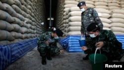 FILE - Soldiers check rice stocks at a warehouse in Ayutthaya province, north of Bangkok, Thailand. 