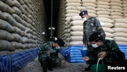 ទាហាន​​​មួយ​​​ក្រុម​​​កំពុង​​​ត្រួត​​​ពិនិត្យ​​​ឃ្លាំង​​​ស្តុក​​​អង្ករ​​​មួយ​​​កន្លែង​​​នៅ​​​ខេត្ត​​​អាយុធ្យា ប្រទេស​​​ថៃ កាល​​​ពី​​​ថ្ងៃ​​​ទី​​​៣​​​ កក្កដា ឆ្នាំ​​​២០១៤។(REUTERS/Chaiwat Subprasom)