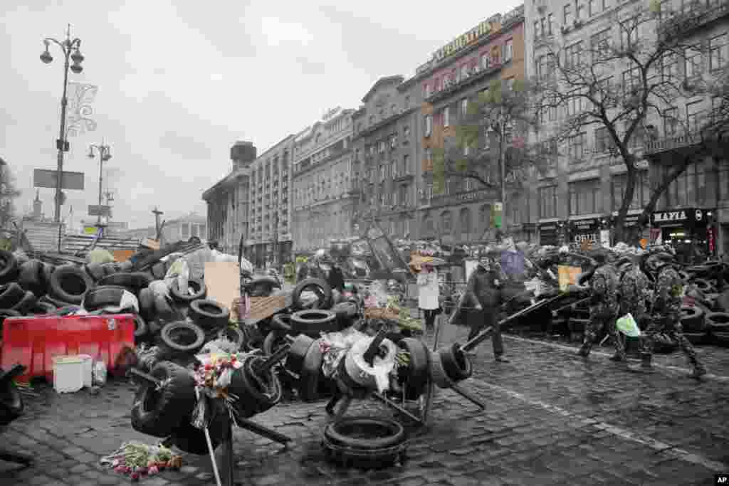 People pass by barricades near the Dnipro Hotel in Kyiv, April 1, 2014. 