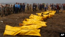 Nepalese rescuers attend to bodies of victims after a passenger plane from Bangladesh crashed at the airport in Kathmandu, Nepal, March 12, 2018.