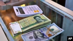 In this Wednesday, May 21, 2019, photo, U.S. and Iranian currency are readied by a money exchanger outside the golden-domed shrine of Imam Moussa al-Kadhim in Kadhimiya district in north Baghdad, Iraq. Many shop owners in Baghdad's northern Shiite…