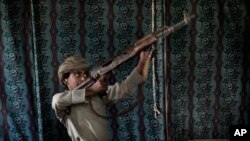 Kahlan, a 12-year-old former child soldier, demonstrates how to use a weapon, at a camp for displaced persons where he took shelter with his family, in Marib, Yemen in this July 27, 2018 photo. (AP Photo/Nariman El-Mofty)