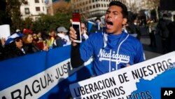 FILE - A demonstrator shouts slogans behind a banner reading in Spanish: "Release of our farmers Political prisoners" and "Nicaragua: Justice" during a protest against the Nicaraguan government in Madrid, Spain, Jan. 12, 2019. 