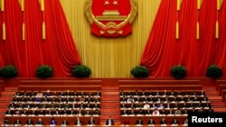 China's President Xi Jinping and other delegates listen as China's Premier Li Keqiang (not pictured) delivers a government work report during the opening session of the National People's Congress (NPC) at the Great Hall of the People in Beijing, China, Ma