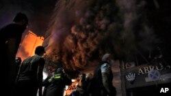 Vatrogasci i spasioci se ispred kompjuterske prodavnice pogođene u izraelskom vazdušnom napadu u centru Bejruta, 17. novembra 2024.