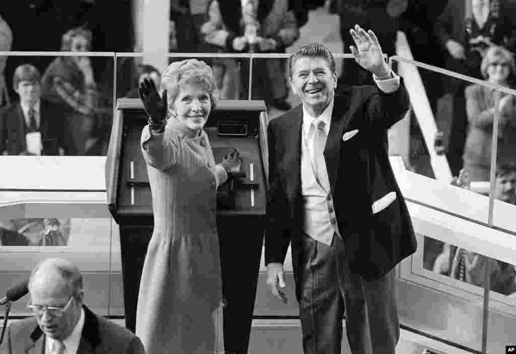 President Ronald Reagan and first lady Nancy Reagan wave to onlookers at the Capitol building as they stand at the podium in Washington following the swearing in ceremony, Jan. 20, 1981.