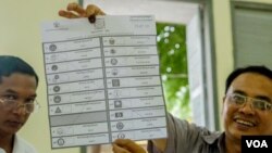 មន្ត្រីរៀបចំការបោះឆ្នោតលើកបង្ហាញសន្លឹកឆ្នោតមួយសន្លឹក​​ បន្ទាប់ពីការិយាល័យ​បោះឆ្នោតនៅទូទាំងប្រទេសបានបិទ នៅសង្កាត់បឹងកេង​កង២ ខណ្ឌ​ចំការមន រាជធានីភ្នំពេញ​ នៅ​ថ្ងៃអាទិត្យ​ ទី២៩ ខែកក្កដា​ ឆ្នាំ២០១៨។ (ខាន់ សុគុំមនោ/VOA)