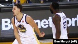 Košarkaši Golden Stejt Voriorsa Klej Tompson (11) i Drejmond Grin (23) raduju se tokom drugog poluvremena šeste utakmice finala Zapadne konferencije NBA plej-ofa