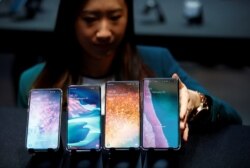 FILE - A Samsung employee arranges the new Samsung Galaxy S10e, S10, S10+ and the Samsung Galaxy S10 5G smartphones at a press event in London, Feb. 20, 2019.