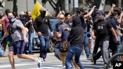 Demonstran anti vaksin (kiri) terlibat pertikaian dengan orang-orang yang berlawanan pendapat dengan mereka dalam sebuah unjuk rasa anti vaksin di depan Balai Kota Los Angeles, AS, pada 14 Agustus 2021. (Foto: AP/Damian Dovarganes)