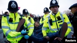 Polisi menahan seorang demonstran perubahan iklim pada aksi protes hari Selasa (16/4) di London.