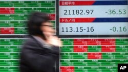 A man walks past an electronic stock board showing Japan's Nikkei 225 index at a securities firm in Tokyo, Dec. 11, 2018. 
