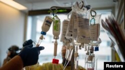 Medical professionals prepare to enter a room where a patients is being treated for coronavirus disease (COVID-19) at the Ochsner Medical Center in Jefferson Parish, Louisiana, U.S., August 10, 2021.