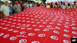 People demonstrate with a national's flags against Tunisia's Islamist-led government, in front of the Constituent Assembly headquarters in Tunis, Tunisia, Sept. 7, 2013. 