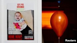 یک بادکنک در کنار پلاکاردی حاوی تصویری از کفیر بیباس، نوزاد اسرائيلی گروگان گرفته شده بدست حماس - آرشیو