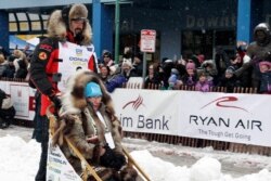 Defending Iditarod Trail Sled Dog Race champion Pete Kaiser of Bethel, Alaska, leaves the start line, March 7, 2020, in Anchorage, Alaska. His mother, Janet, is riding in his sled with him.