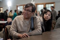 S'Tha Sein, left, and his daughter Lunn KyiPhyu Tha, 15, right, both immigrants from Myanmar, also known as Burma, speak with a reporter from The Associated Press following services, Feb. 16, 2020, at the Overseas Burmese Christian Fellowship.