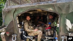在靠近乌俄边界的乌克兰苏梅州，从俄罗斯库尔斯克州返回的乌克兰军人坐在一辆装甲车内。(2024年8月14日)