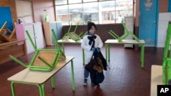 Seorang murid memasuki ruang kelasnya untuk pertama kali setelah ditutup selama tiga bulan untuk mencegah penyebaran virus corona di Montevideo, Uruguay, 15 Juni 2020. 