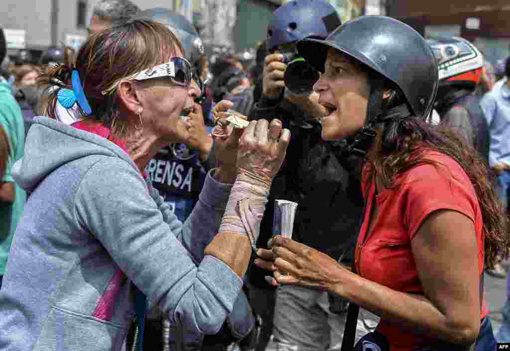 Backers of the government of Venezuela&#39;s President Nicolas Maduro (L) and opposition activists face off in front of the Supreme Court of Justice in Caracas.
