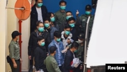 ក្រុមសកម្មជន​គាំទ្រ​លទ្ធិ​ប្រជាធិបតេយ្យ​រួមមាន​លោក Alvin Yeung លោក Eddie Chu និង​លោក Jeremy Tam ដើរ​ទៅ​រថយន្ត​ដែល​នឹង​ដឹក​ពួកគេ​ពី​ពន្ធនាគារ​ទៅ​តុលាការ​នៅក្នុង​ទីក្រុង​ហុងកុង នៅ​ថ្ងៃទី២ ខែមីនា ឆ្នាំ២០២១។