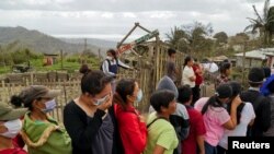 FILE - Residents, who refuse to evacuate, queue for relief goods following Taal Volcano's eruption, in Talisay, Batangas, Philippines, Jan. 20, 2020. 