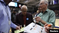 Para petugas memeriksa dokumen di sebuah kaukus di Des Moines, Iowa, 3 Februari 2020.