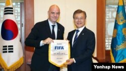 문재인 한국 대통령(오른족)이 12일 청와대에서 지아니 인판티노 국제축구연맹(FIFA) 회장으로부터 받은 선물을 들고 기념촬영을 하고 있다.