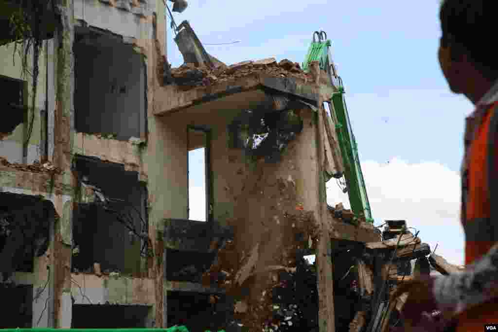 ទិដ្ឋភាព​នៃ​ការ​វាយកម្ទេច​អគារប៊ូឌីញ​ "អគារ ស​" ក្នុង​រាជធានី​ភ្នំពេញ​ នាថ្ងៃទី៣​ ខែសីហា​ ឆ្នាំ២០១៧។ ​អគារ​ប៊ូឌីញ​ កសាង​ឡើង​ក្នុង​អំឡុង​ឆ្នាំ១៩៦០​ ហើយ​អគារ​នេះ​ចាប់ផ្តើម​វាយកម្ទេច​នា​ខែ​ កក្កដា​ ឆ្នាំ​២០១៧។ ​(រ៉ាវី សុភារ័ត្ន/VOA)