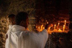 A father and his son go to the oldest church in Ethiopia to be blessed, in Axum, Ethiopia, June 13, 2021. (Yan Boechat/VOA)