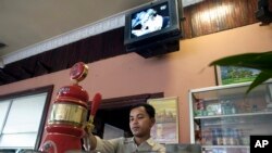 អ្នក​លក់​ស្រាបៀ​កំពុង​ចាក់​ស្រាបៀ​ជូន​អតិថិជន​កាល​ពី​ថ្ងៃពុធ ទី១ ខែ​មេសា ឆ្នាំ​២០០៩ នៅ​ទីក្រុង​ភ្នំពេញ។ (រូបថត៖ AP/David Longstreath)